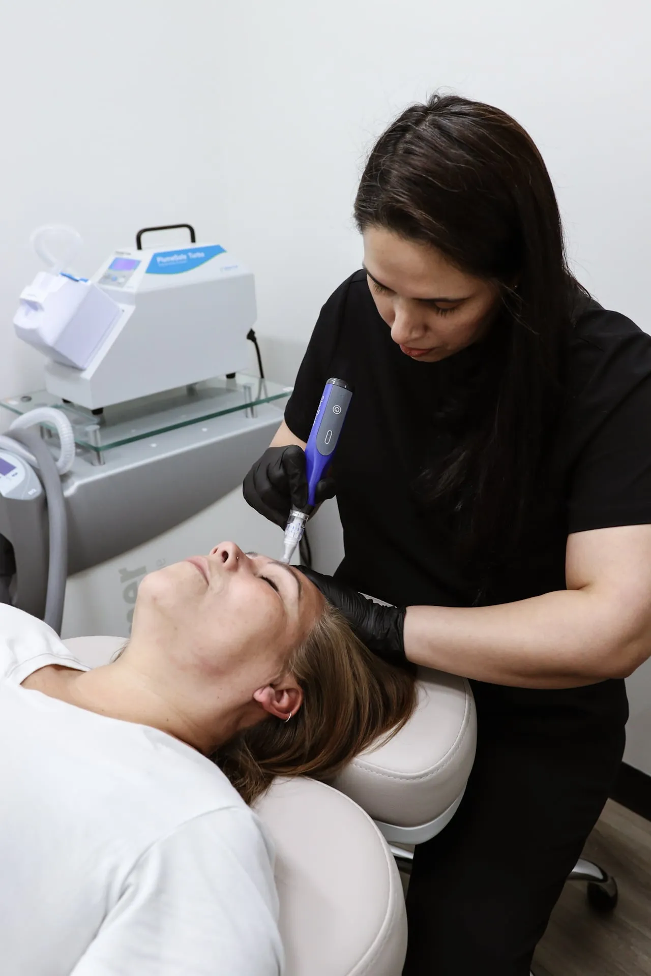 A clinician treats a patient’s forehead with the SkinPen microneedling device
